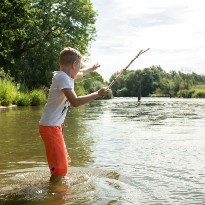 Child Using Fishing Kit to Fish in a River